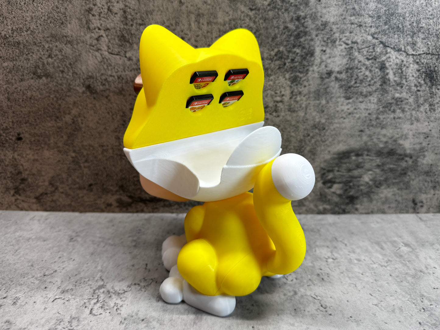 
                  
                    a yellow cat toy sitting on top of a table
                  
                