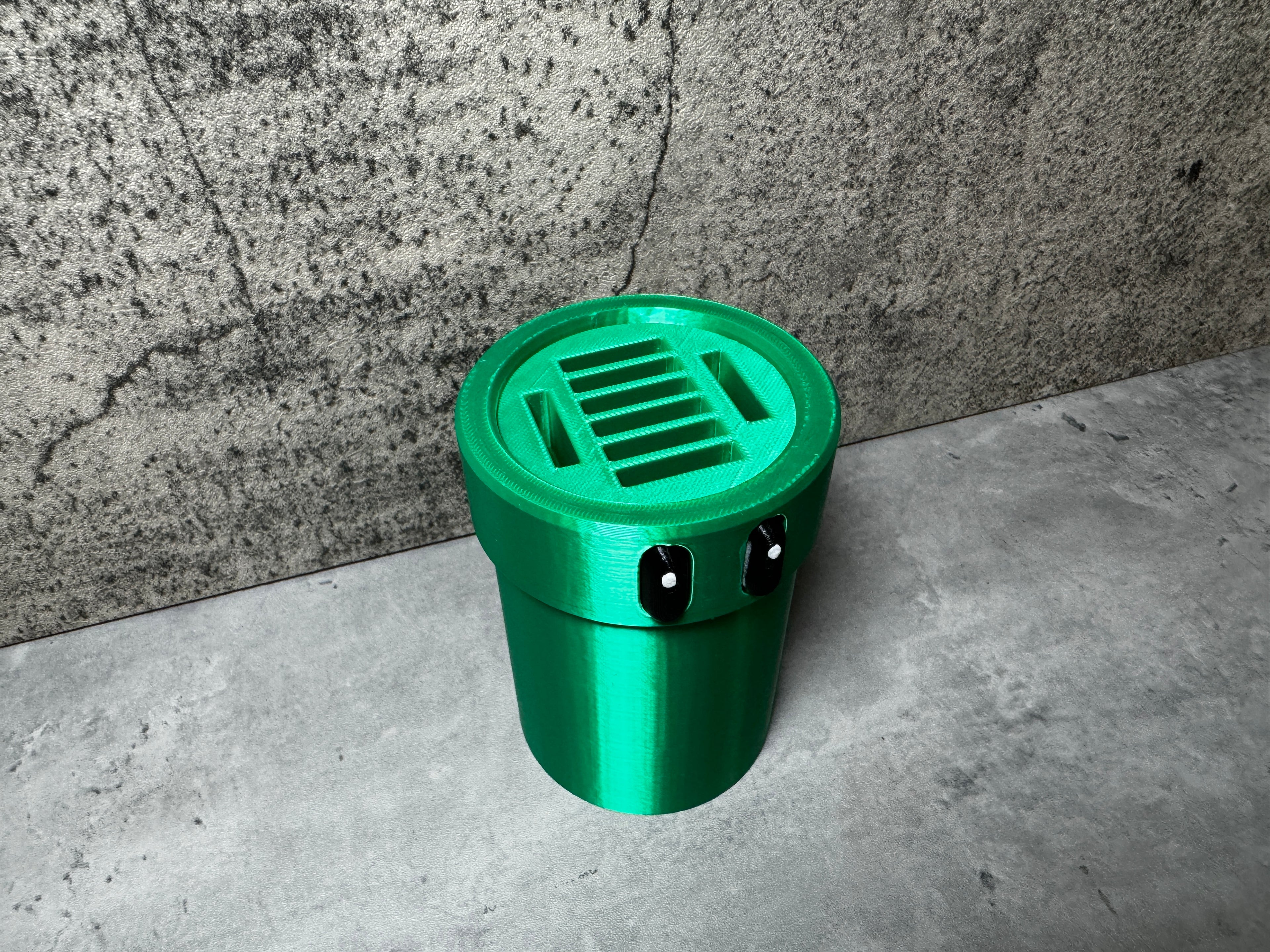 a green trash can sitting in front of a wall