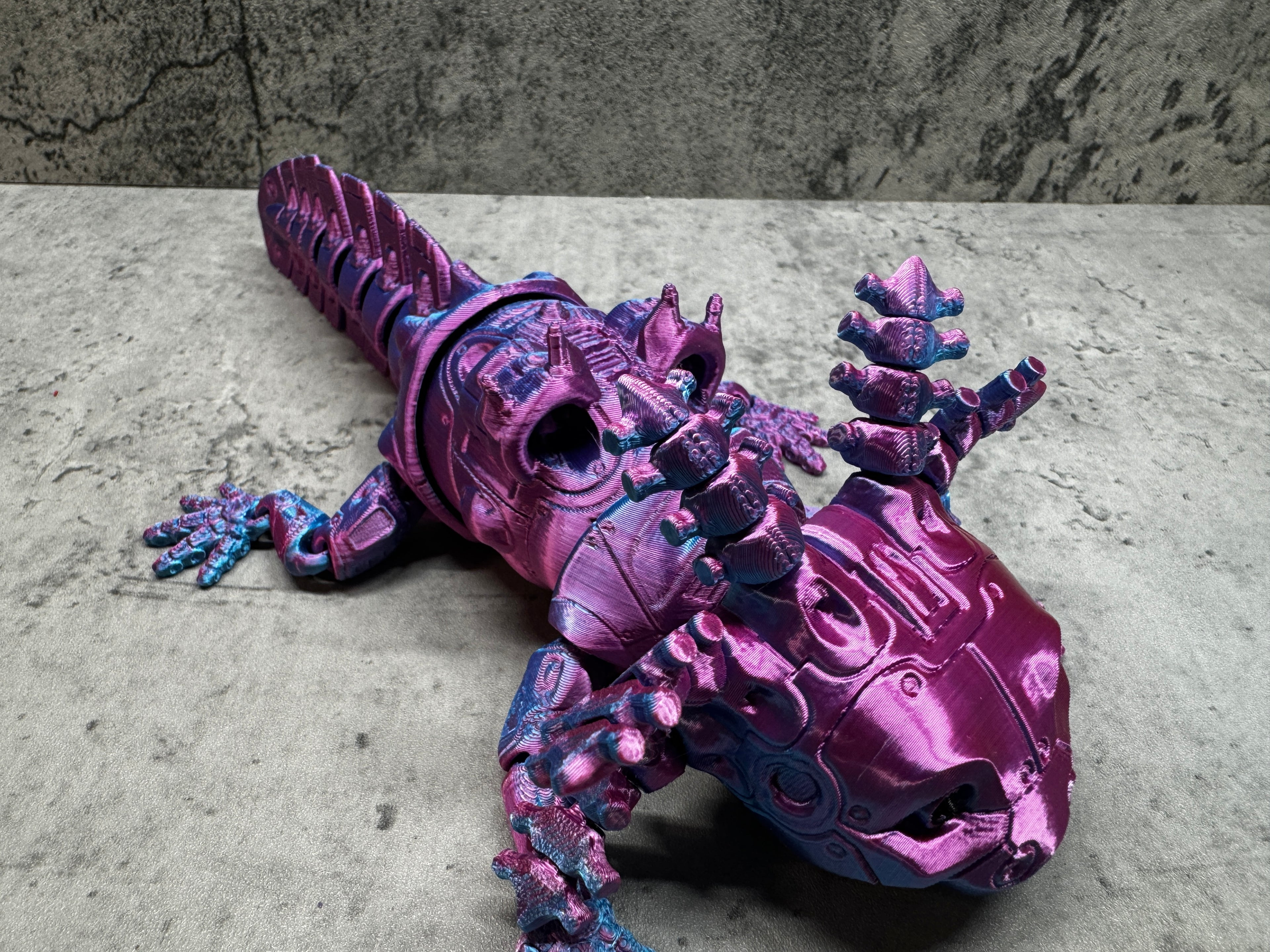 a purple toy lizard sitting on top of a table